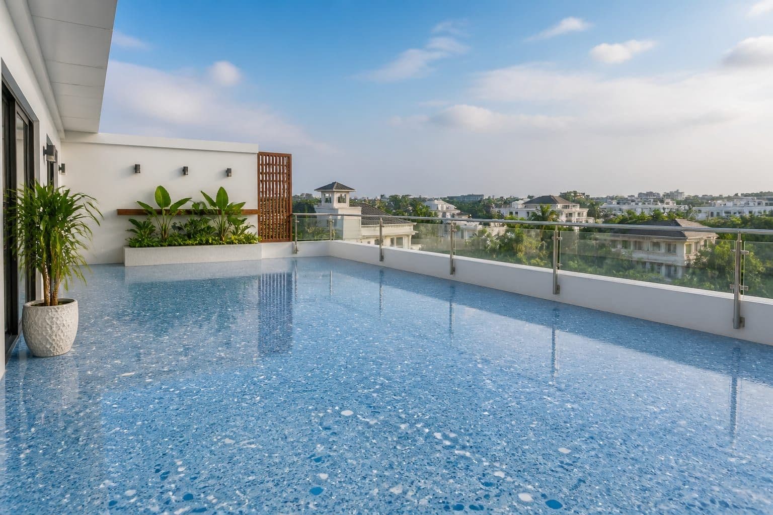 Wide outdoor rooftop terrace with polished sky-blue terrazzo and glass railings